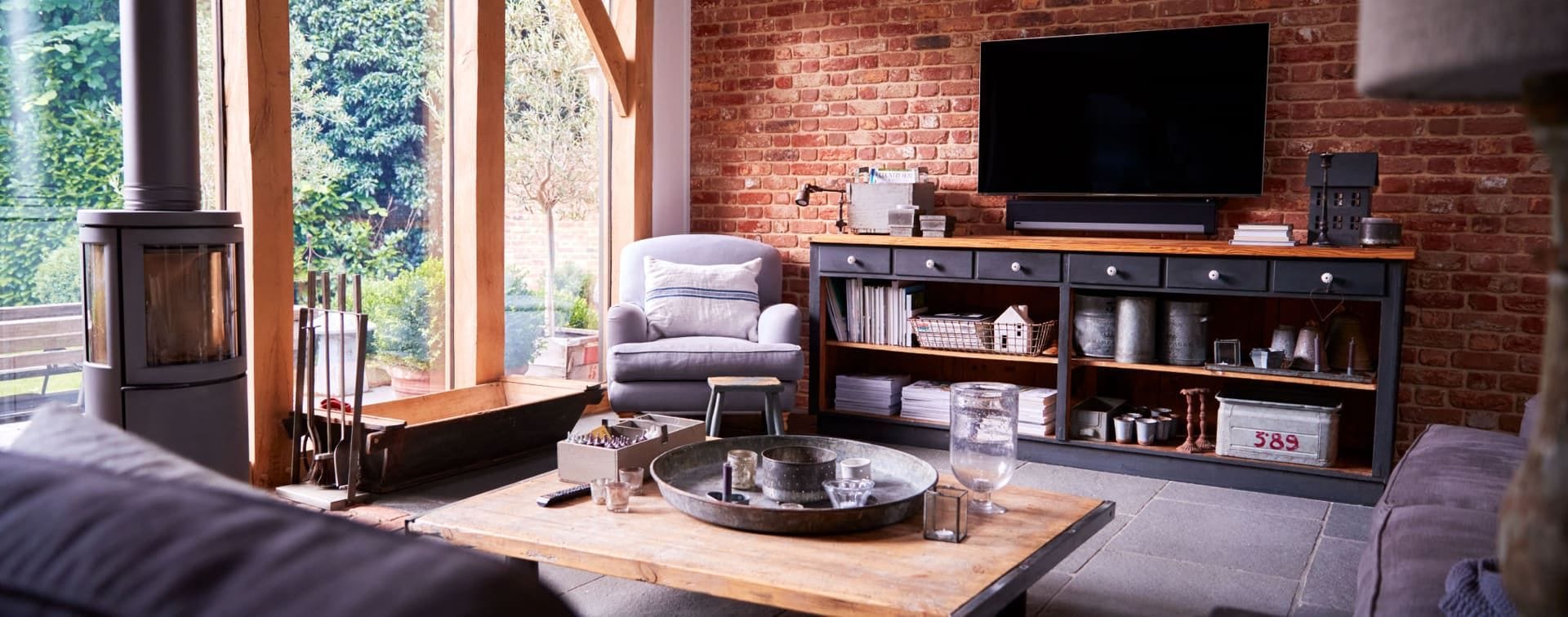 Refurbished living room with exposed beams and arched windows